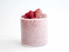 a glass filled with fruit on top of a white table