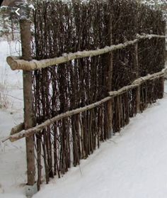 a fence made out of branches in the snow