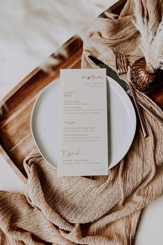 a white plate with a menu on it next to a fork and knife in front of a napkin