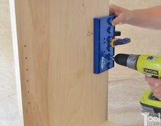 a person using a power drill to attach a piece of wood