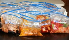 several bags of food sitting on top of a table next to each other with blue handles