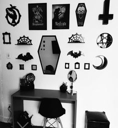 a red table sitting in front of a white wall with lots of halloween decorations on it