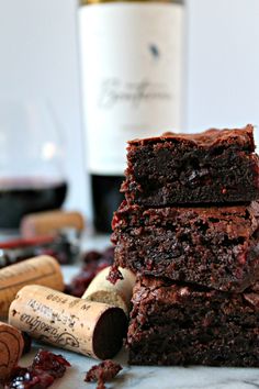 three brownies stacked on top of each other next to some wine bottles and corks