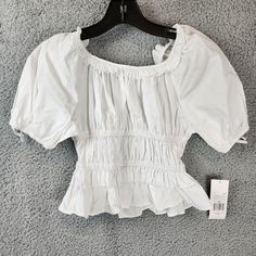 Habitual Ruffle Top Girls' 10 White Elasticized Ruffled Neckline Raglan Sleeves Habitual Ruffle Top Girls' 10 White Elasticized Ruffled Neckline Raglan Sleeves Retail $48.00 Make Your Little Girl Stand Out In This Beautiful White Ruffle Top From Habitual. The Top Features A Scoop Neckline With Elasticized Ruffles And Short Raglan Sleeves. It Is Made Of A Blended Fabric Consisting Of Nylon, Cotton, And Elastane, Making It Breathable And Perfect For Summer Or Spring. This Casual Top Is Easy T White Puff Sleeve Top With Ruffles, White Smocked Top With Ruffles And Short Sleeves, Ruffle Shoulder Top, Ruffled Tops, White Ruffle Top, Top Girls, Ruffled Neckline, Girl Standing, Ruffle Shirt