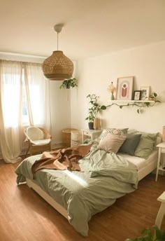 a bed sitting in a bedroom next to a white desk and chair with a plant on top of it