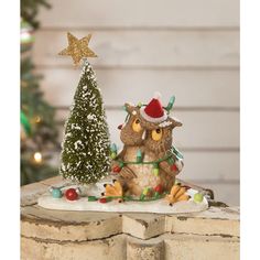 an owl figurine sitting next to a christmas tree