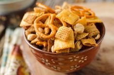 a bowl filled with cheetos sitting on top of a wooden table