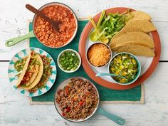 mexican food is laid out on plates and placemats, including tortillas