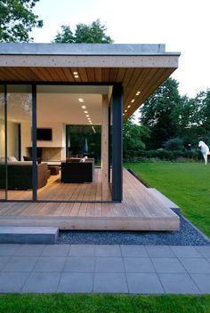 an outdoor living area with wooden decking and sliding glass doors on the outside wall