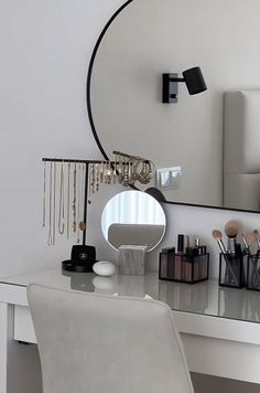 a white desk topped with a mirror and lots of makeup