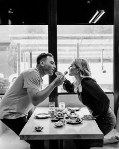 a man and woman sitting at a table eating food