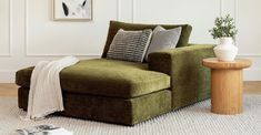 a living room with a green couch and white rug