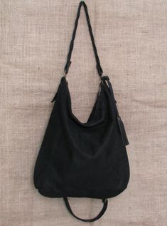 Handmade black suede hobo bag. This bag is unlined, inside there is a big cotton zipped pocket. The bag is closed with a zip The handle is an handmade leather braid. The sholder belt is removable and adjustable. This confortable hobo bag is very practical for any occasion. This bag is very large and soft and may contain many things. Features : - Black suede, - Unined, - Metal finishes are brass colored, - Closed with zip, - Inside zipped pocket, - Removable shoulder belt. Size : - Heigth 16 inch Black Suede Bag With Detachable Strap, Everyday Black Suede Shoulder Bag, Suede Hobo Bag With Zipper For Everyday Use, Suede Hobo Bag With Zipper For Daily Use, Suede Hobo Bag With Zipper Closure For Daily Use, Everyday Suede Hobo Bag With Zipper Closure, Black Suede Crossbody Bag, Suede Hobo Bag, Shoulder Belt