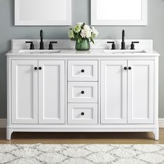 two white double sinks with mirrors above them in a gray and white bathroom, along with a rug on the floor