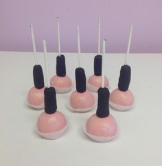 there are many pink and black candys with white sticks sticking out of the top