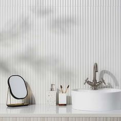 a white sink sitting on top of a counter next to a mirror and soap dispenser