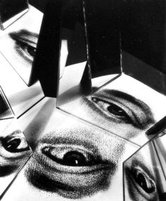 black and white photograph of an eye surrounded by cubes with mirrors on it's sides