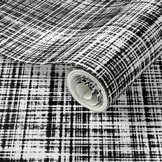 black and white checkered fabric with a rolled up roll on the floor next to it