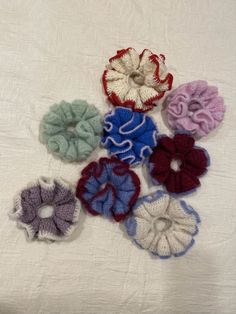 several crocheted scrunffles are arranged on a white surface, including one in the middle