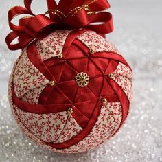 a red and white ornament sitting on top of glittery silver tablecloth