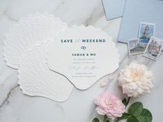 the wedding stationery is laid out next to flowers and postcards on a marble surface