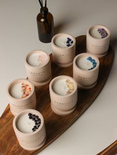 six cups are sitting on a wooden tray