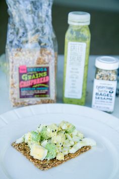 a white plate topped with food next to a bag of granola and two bottles