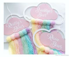 three pink, yellow and blue tasselled hair clips with words reading brooklyn's boys on them