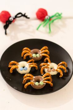 some pretzels are on a black plate with spider webs in the background