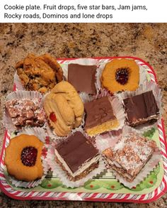 a tray filled with cookies and desserts on top of a counter