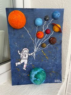 an image of a painting on the side of a window sill with balloons and planets