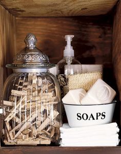 a wooden shelf with soaps, toothbrushes and other bathroom items in it