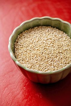 a bowl filled with sesame seeds on top of a red table