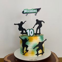 a birthday cake decorated with the silhouettes of skateboarders on top of it