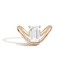 an emerald - cut diamond ring in yellow gold with curved shans on the band