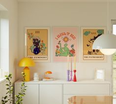 a living room with posters on the wall and a table in front of it next to a window