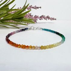 This colorful, dainty beaded bracelet is made with tiny 2mm faceted round gemstone beads in a rainbow of gorgeous colors! The gemstones are arranged in an ombre shaded pattern, and include a variety of semi-precious stones and crystals carefully strung on flexible aluminum wire. Perfect for celebrating or showing your support for Pride, or just for those who love rainbows and colorful jewelry! This piece can also be made as an anklet or necklace, just select the length you prefer or message us w Rainbow Crystal Bracelet With Gemstone Round Beads, Rainbow Crystal Bracelet With Round Gemstone Beads, Rainbow Crystal Bracelet With Colorful Round Beads, Rainbow Gemstone Beaded Bracelet, Bohemian Faceted Crystal Bracelet With Round Beads, Rainbow Beaded Bracelets With Faceted Beads For Gift, Rainbow Faceted Beads Bracelet As Gift, Rainbow Gemstone Beaded Round Bracelets, Rainbow Gemstone Beads Bracelet With Round Beads