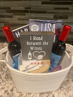 a basket filled with wine bottles sitting on top of a counter next to a sign that reads i read between the wines