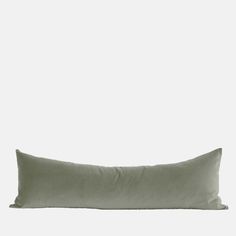 an olive green pillow on a white background