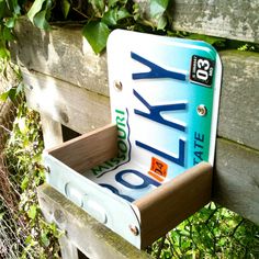 a close up of a wooden bench with a license plate holder on it's back