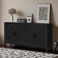 a black sideboard with geometric designs on the doors and drawers in front of it