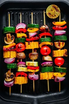 several skewers with vegetables and meat on them sitting on top of a grill