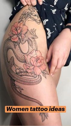 a woman with a tattoo on her thigh holding onto a snake and flowered arm