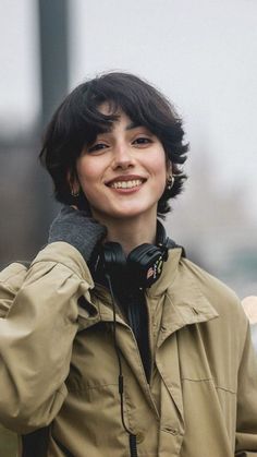 a woman wearing headphones is smiling for the camera