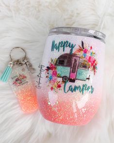 the happy camper glitter tumbler is next to a keychain on a furry surface