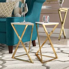 two side tables sitting on top of a rug next to a blue chair and coffee table