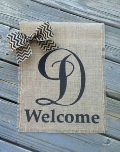 a welcome sign with a chevron bow on it's front door hanger