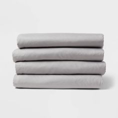 four sheets stacked on top of each other in grey linens, with one folded over the