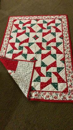 two quilts are laying on the floor next to each other and one is red, green and white