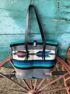 This tote bag is handmade out of a small saddle blanket and high quality leather for the handles. It has a turn-lock clasp for the top closure.  -The strap drop is 11.5".  -The bag measurements are: W~18", H~14", D~5" at the bottom. Thank you for your interest in supporting my small business! You can also check out my website at rockinhrwesterndesigns.com Saddle Blanket, Fabric Bags, Weekender Bag, High Quality Leather, Large Bags, Saddle, Shoulder Bag, Tote Bag, Pet Supplies